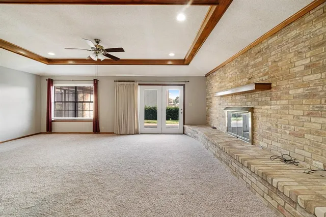 a view of an empty room with a fireplace and a window