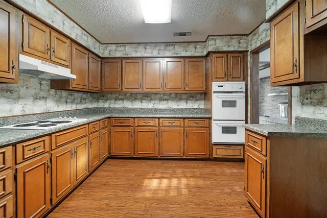a kitchen with stainless steel appliances granite countertop a sink stove and cabinets