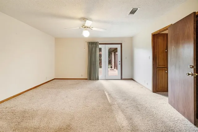 a view of an empty room with a chandelier fan