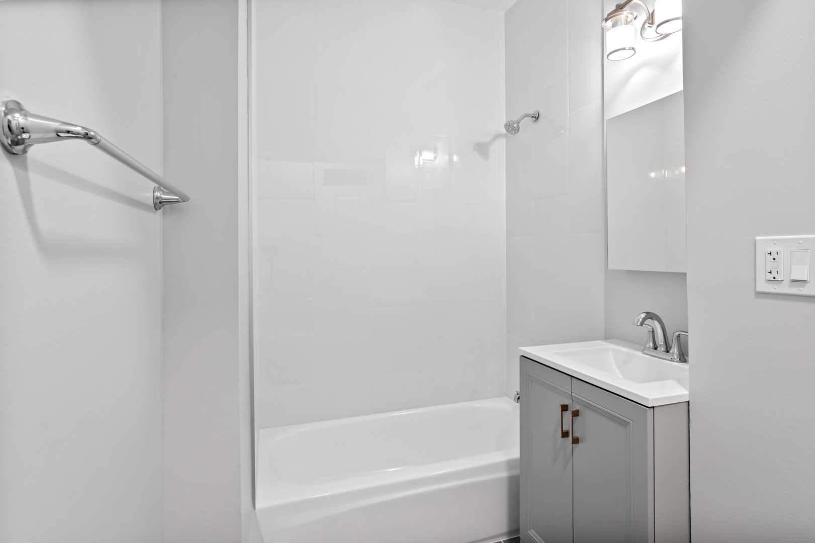 7600 North Sheridan Road, Unit 107 Chicago, IL 60626 - Photo 7 of 9 a bathroom with a tub sink vanity and a mirror