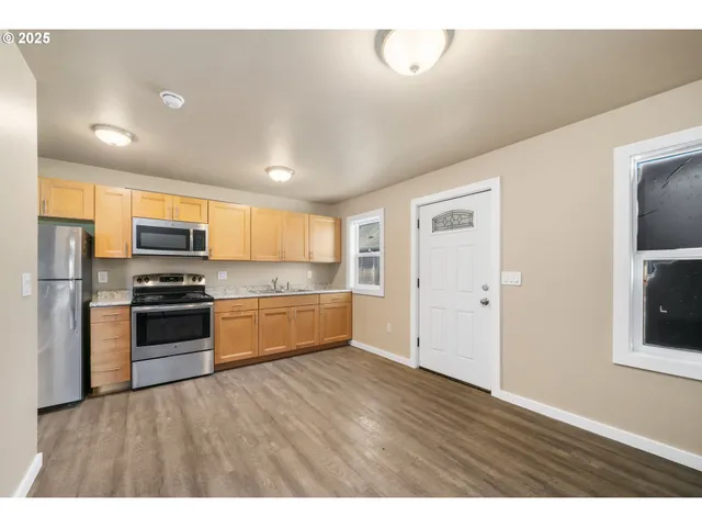 a kitchen with stainless steel appliances granite countertop a stove a sink and a refrigerator