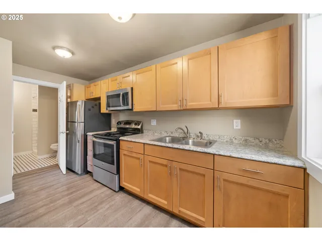 a kitchen with granite countertop wooden cabinets a sink and dishwasher