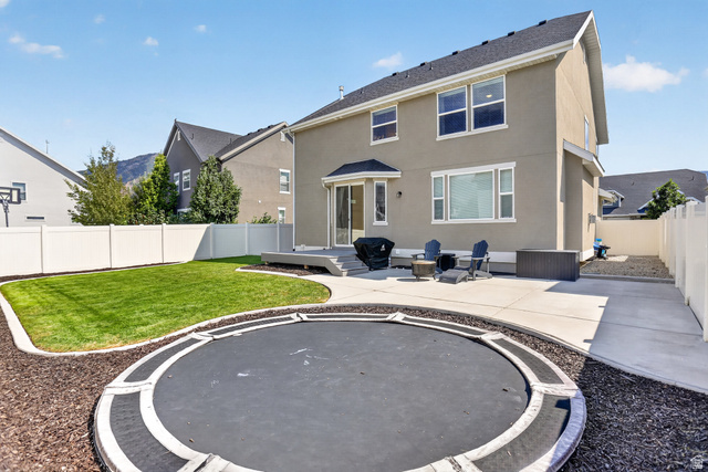 2178 Autumn Drive Mapleton, UT 84664 - Photo 41 of 48 Backyard featuring a stucco exterior, a patio with a built-in fire pit, a raised deck, and a manicured lawn