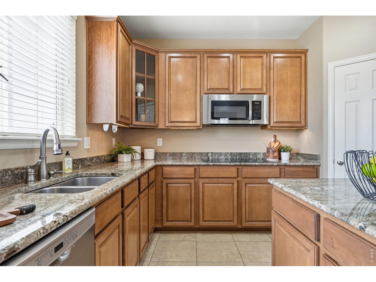 1277 Mathews Way Erie, CO 80516 - Photo 11 of 40 a kitchen with stainless steel appliances granite countertop a stove a sink and a microwave