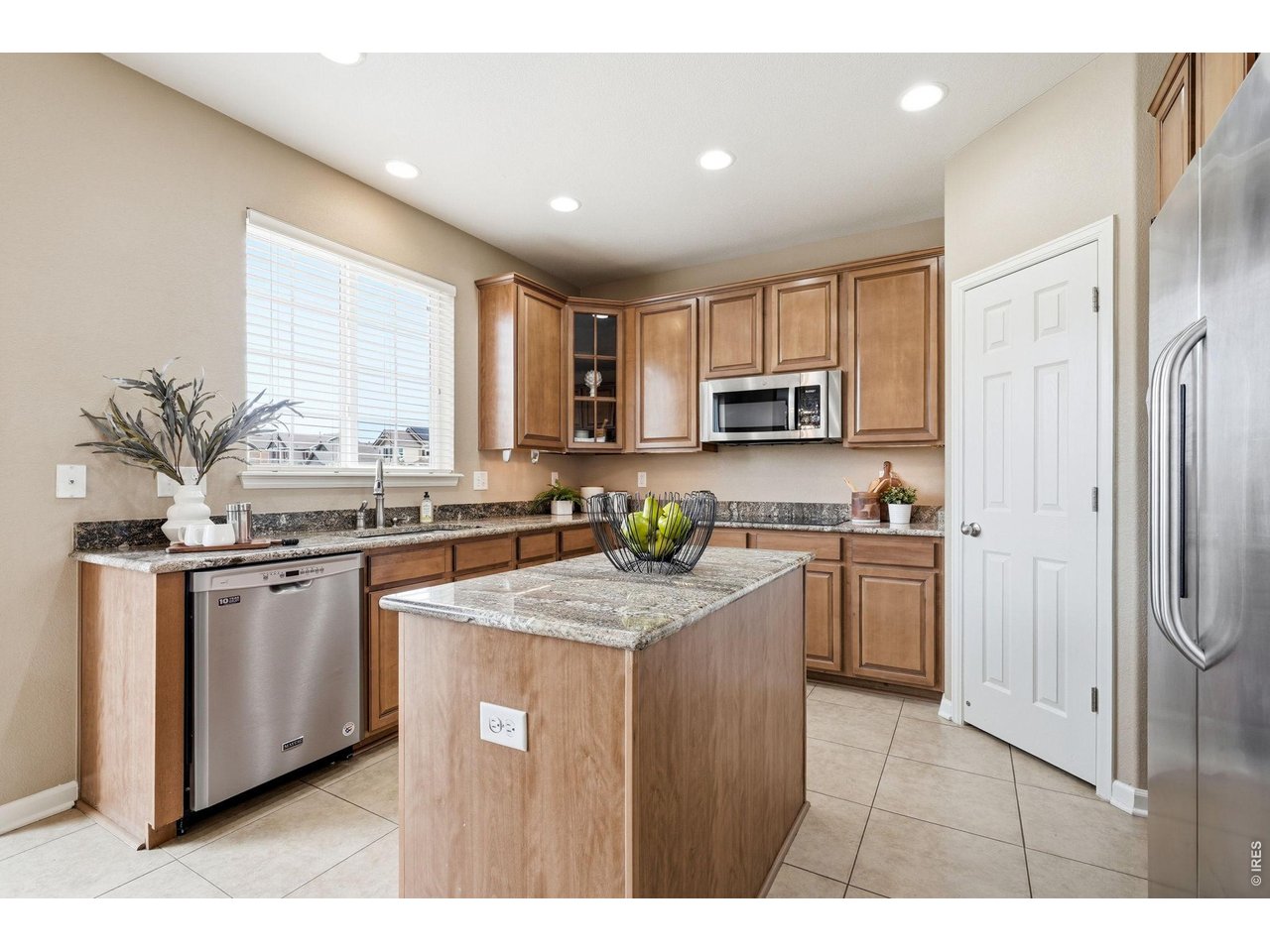 1277 Mathews Way Erie, CO 80516 - Photo 12 of 40 a kitchen with stainless steel appliances granite countertop a sink a stove a refrigerator cabinets and a window