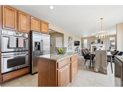a kitchen with stainless steel appliances granite countertop a sink a stove a refrigerator cabinets and a window