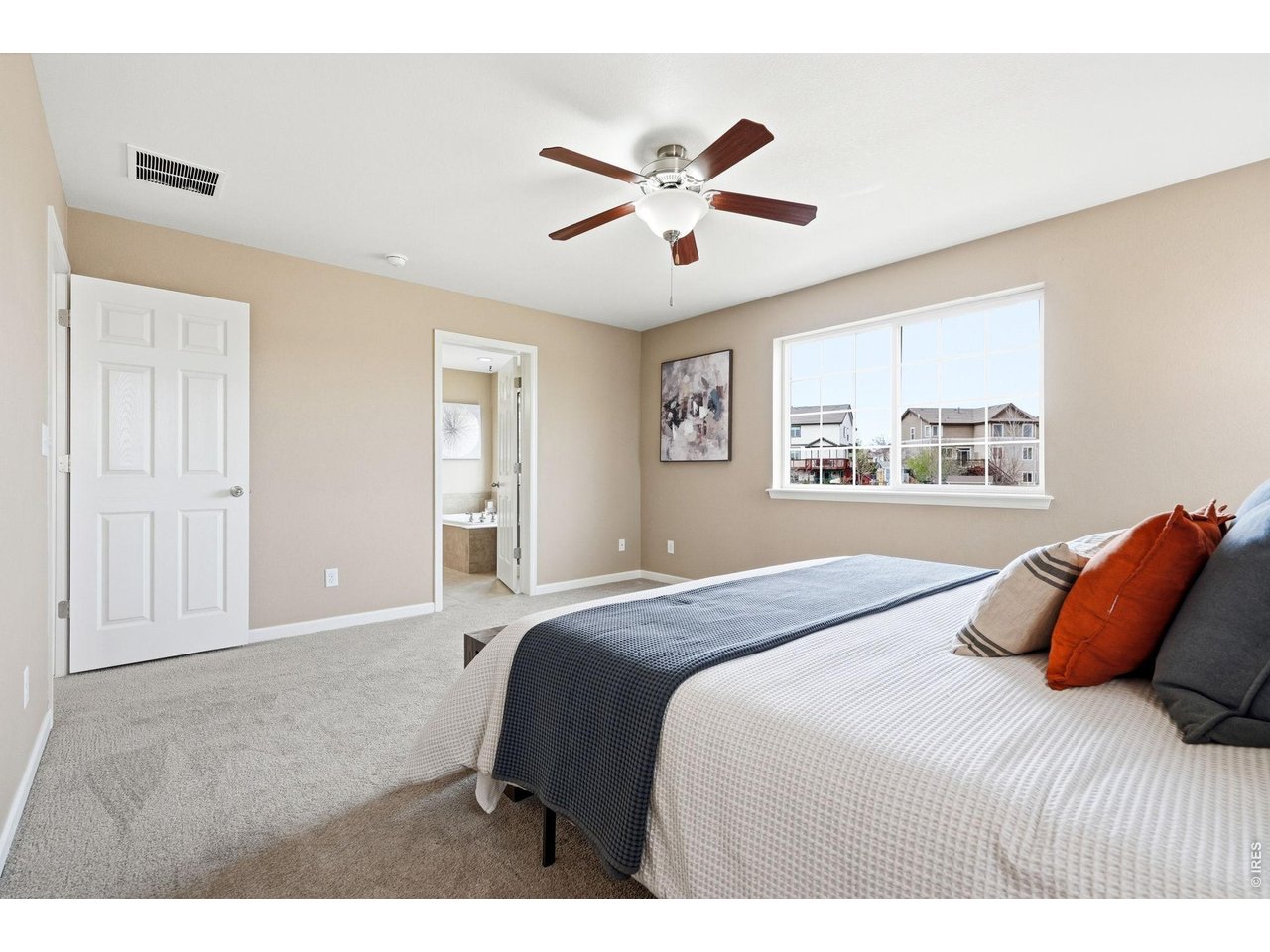1277 Mathews Way Erie, CO 80516 - Photo 17 of 40 a bedroom with a large bed and a chandelier