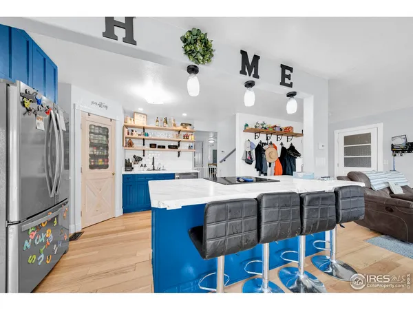 a kitchen with stainless steel appliances kitchen island granite countertop a table chairs in it and wooden floors