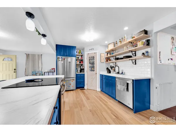 a kitchen with stainless steel appliances kitchen island granite countertop a sink stove and refrigerator
