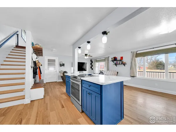 a kitchen view with wooden floor and windows