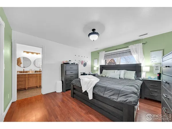 a bedroom with a bed and dresser with mirror