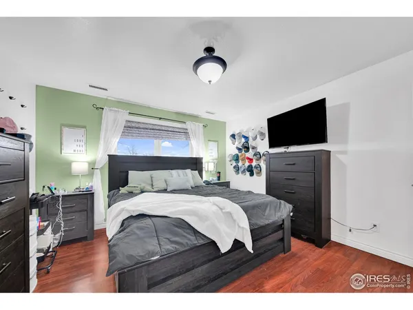a bedroom with a bed and a flat screen tv