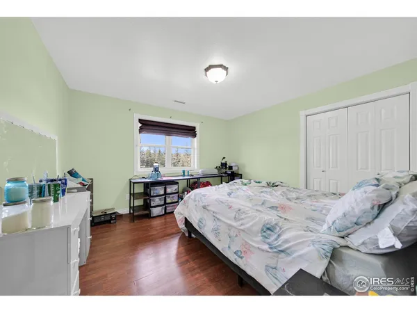 a bedroom with a bed window and a flat screen tv