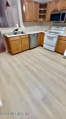a view of kitchen with stainless steel appliances granite countertop sink and stove