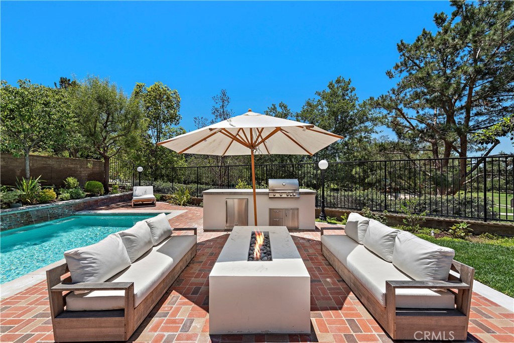 2 Anna Lane Ladera Ranch, CA 92694 - Photo 5 of 63 a view of a patio with couches chairs under an umbrella with a yard