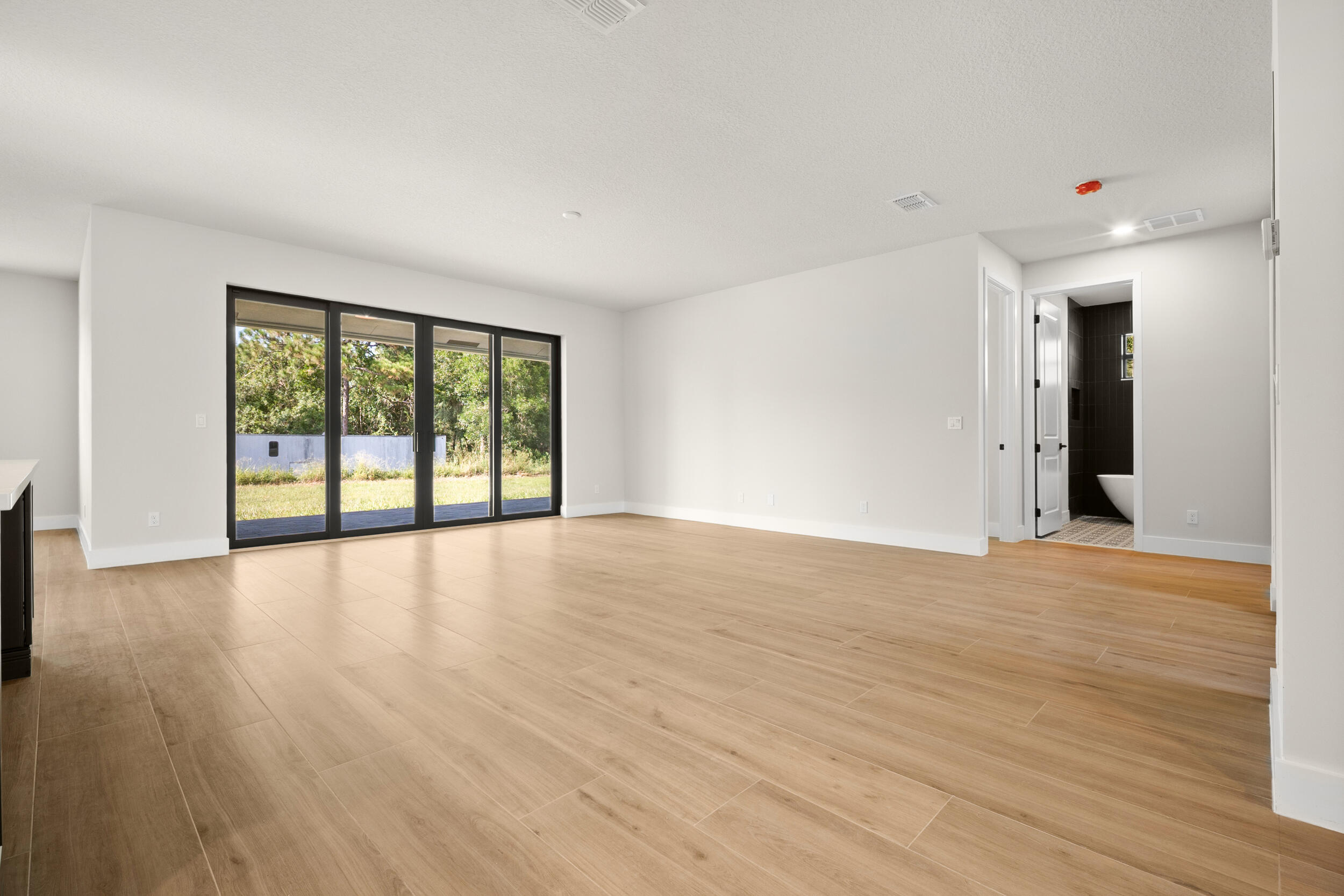 1142 Southwest Abbey Avenue Port St. Lucie, FL 34953 - Photo 11 of 57 a view of an empty room with wooden floor and a window