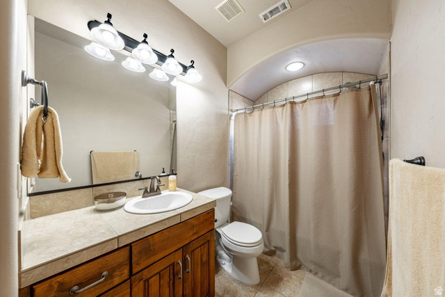 1609 East 10 S Street St. George, UT 84790 - Photo 49 of 68 Bathroom featuring a wood-finish vanity with a tile countertop, integrated sink, and a multi-bulb vanity light fixture