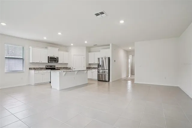 a view of kitchen with sink and refrigerator