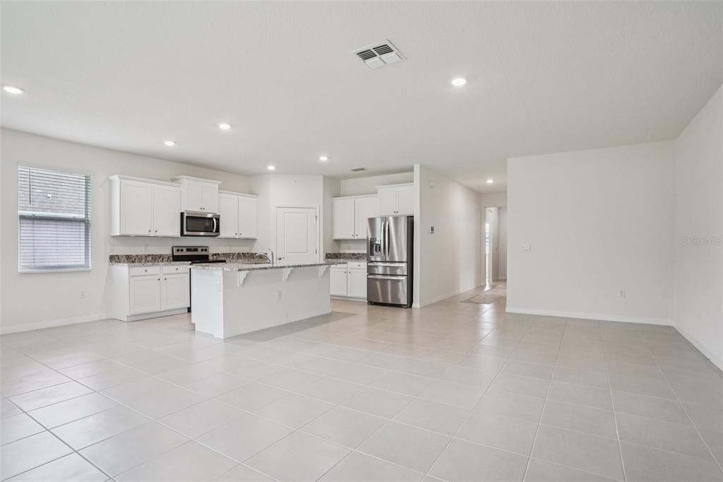 6203 Southwest 93rd Loop Ocala, FL 34476 - Photo 13 of 54 a large kitchen with white cabinets and stainless steel appliances