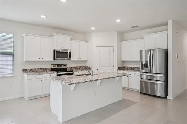 a living room with furniture kitchen view and a potted plant