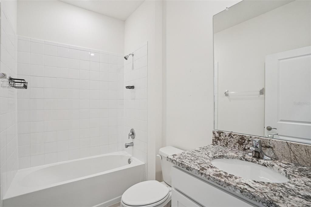 6203 Southwest 93rd Loop Ocala, FL 34476 - Photo 29 of 54 a bathroom with a granite countertop toilet sink and bathtub