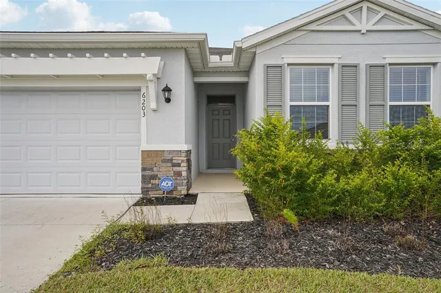 a front view of a house with swimming pool and palm tree