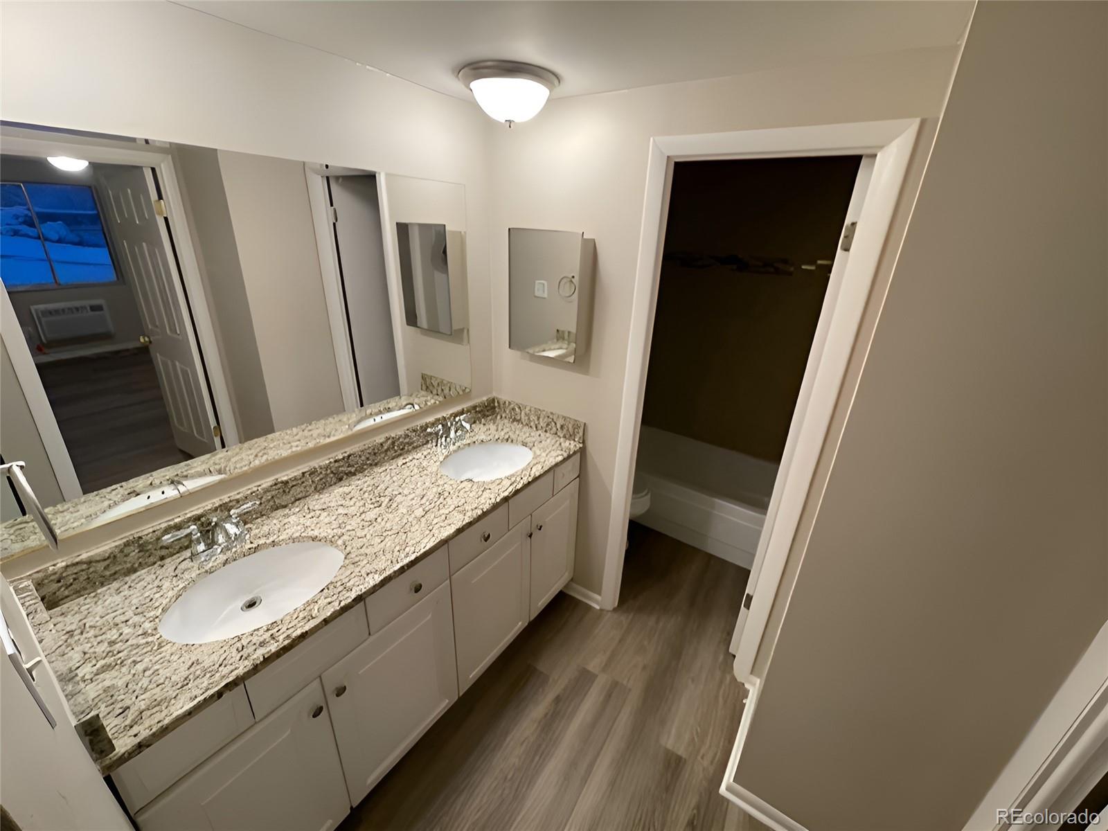 1304 South Parker Road, Unit 148 Denver, CO 80231 - Photo 14 of 23 a bathroom with a double vanity sink and mirror
