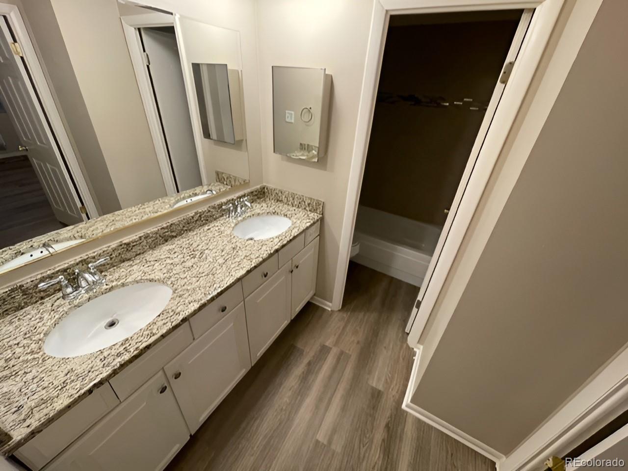 1304 South Parker Road, Unit 148 Denver, CO 80231 - Photo 18 of 23 a bathroom with a granite countertop sink and a mirror