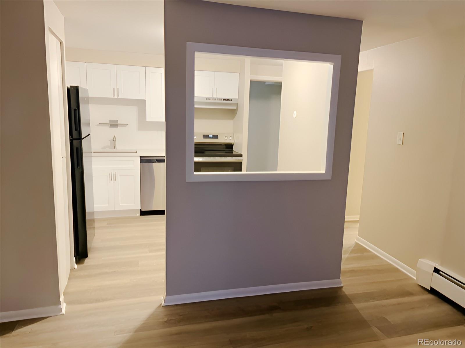 1304 South Parker Road, Unit 148 Denver, CO 80231 - Photo 21 of 23 a view of a kitchen from the hallway with a dining room