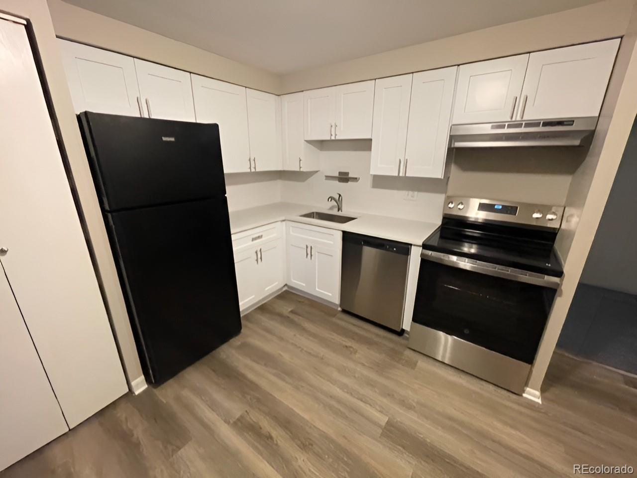 1304 South Parker Road, Unit 148 Denver, CO 80231 - Photo 5 of 23 a kitchen with a sink and a refrigerator