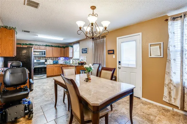a view of a dining room with furniture a chandelier and wooden floor