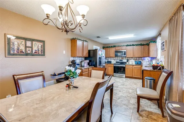 a view of a dining room with furniture a chandelier and wooden floor