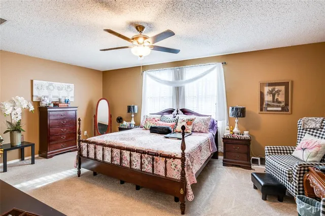 a bedroom with a bed a chandelier and a dresser