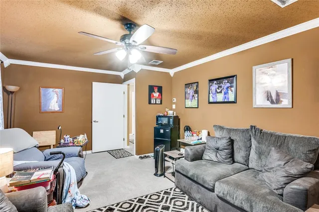 a living room with furniture and a ceiling fan