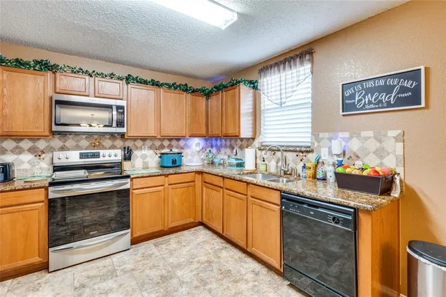 a kitchen with stainless steel appliances granite countertop a stove sink and cabinets