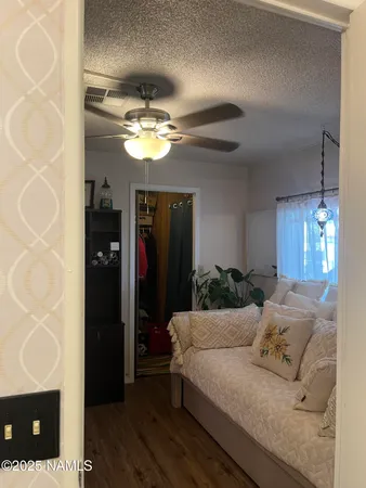 a living room with furniture chandelier and a ceiling fan