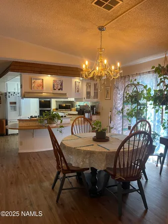 a view of a dining room with furniture and chandelier