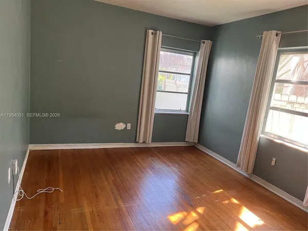 a view of empty room with wooden floor