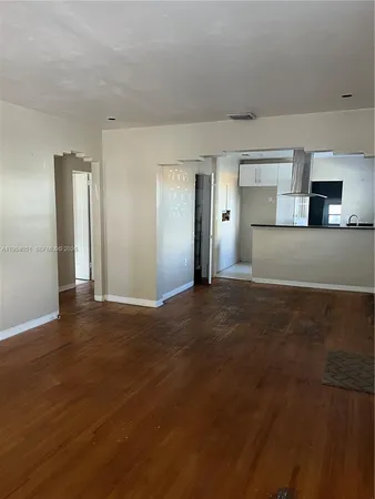 a view of empty room with wooden floor and fireplace