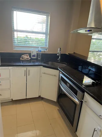a kitchen with a sink and a stove next to a window
