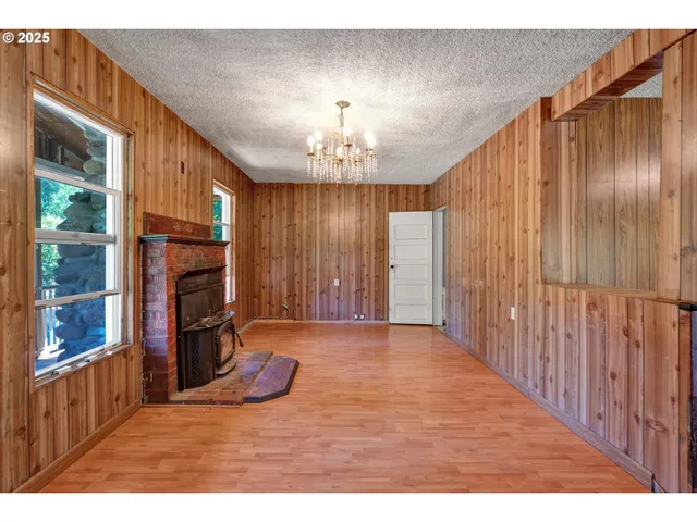 a view of an empty room with a fireplace and a window