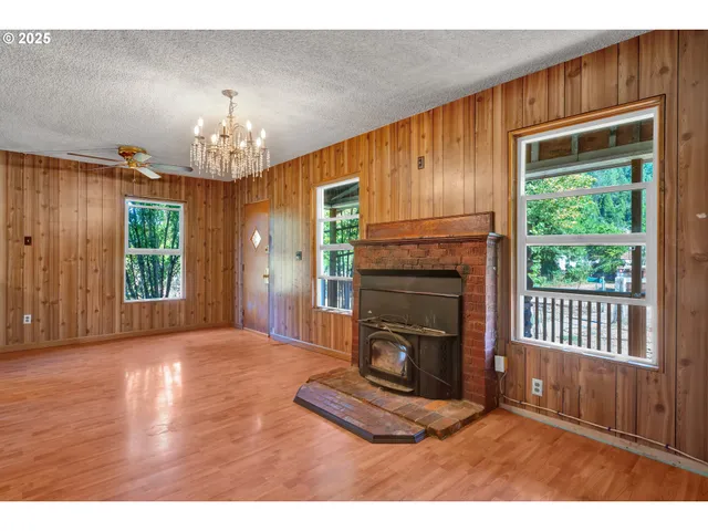 a view of a livingroom with a fireplace window and wooden floor