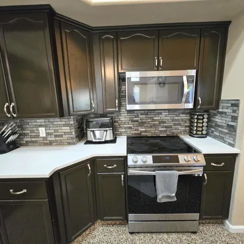 a kitchen with granite countertop a stove and a microwave