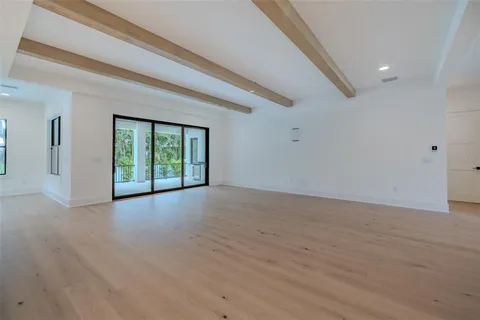 a large white kitchen with kitchen island a sink dishwasher stove and wooden floors