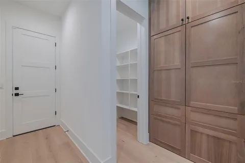 a view of a hallway with wooden cabinets