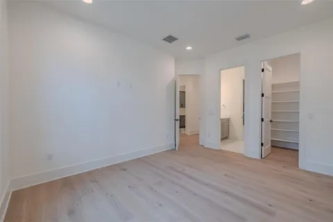 a view of a yard in front of a house with plants and large tree
