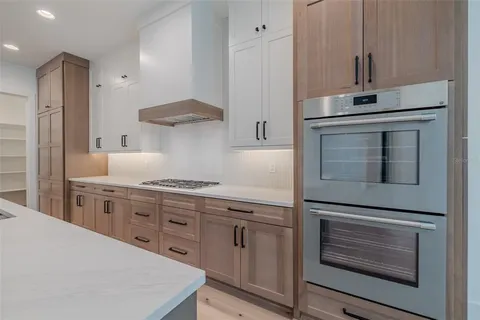 a bathroom with double vanity sink a two mirror a window and a bathtub