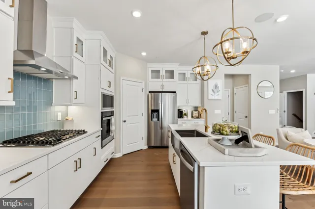 a kitchen with a sink a stove and white cabinets