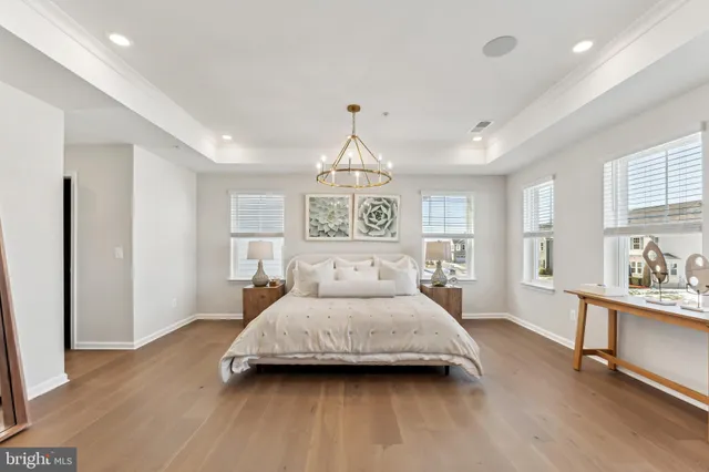 a spacious bedroom with a bed and a chandelier