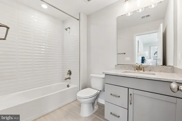 a spacious bedroom with a bed and a dresser